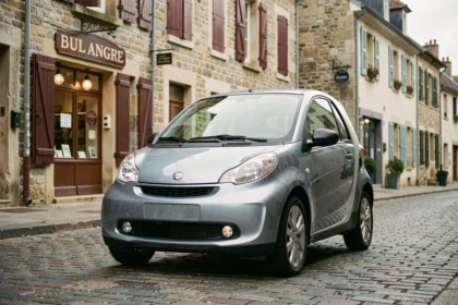 Voiture sans permis d'occasion garée dans une rue pavée de Dijon avec façades en pierre bourguignonne